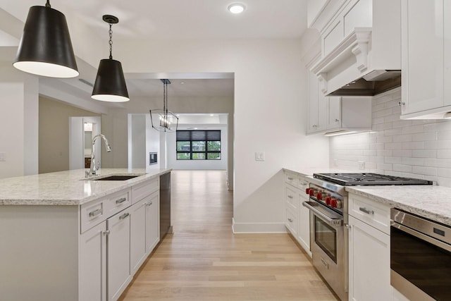 222 Ferndale Rd S Unit 207, Wayzata, MN 55391 - kitchen with appliances with stainless steel finishes, light wood-type flooring, tasteful backsplash, hanging light fixtures, and white cabinetry