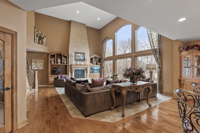 living area featuring a high ceiling, light wood finished floors, and recessed lighting