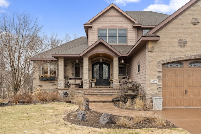 doorway to property featuring brick siding, roof with shingles, and french doors