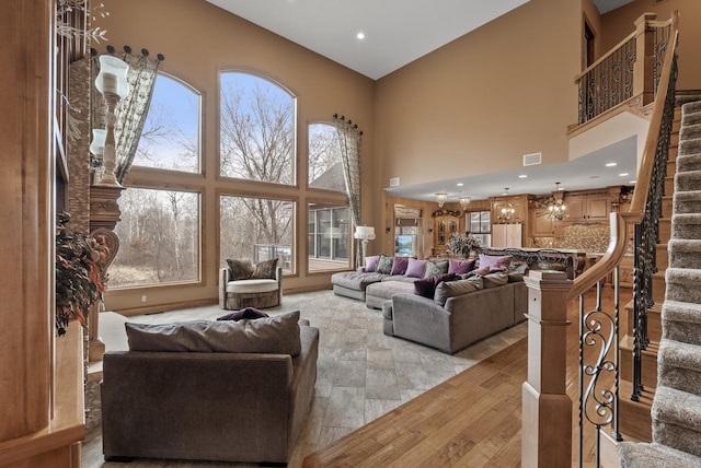 living room featuring a high ceiling, recessed lighting, visible vents, and stairway