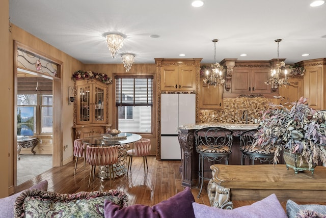 kitchen with backsplash, freestanding refrigerator, plenty of natural light, and a notable chandelier