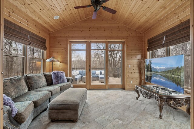 living area with wooden ceiling, wooden walls, ceiling fan, and vaulted ceiling