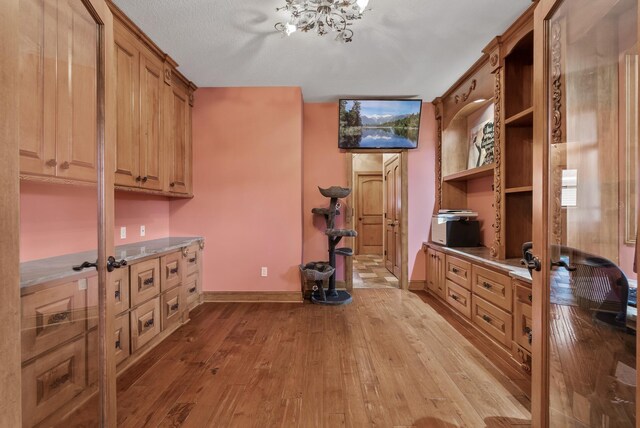 interior space with wood-type flooring, baseboards, and a chandelier
