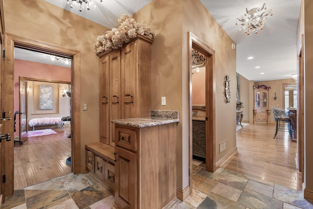 mudroom featuring stone finish flooring, recessed lighting, visible vents, and baseboards