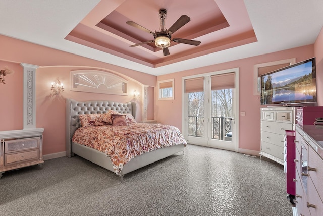 bedroom with baseboards, a ceiling fan, visible vents, access to exterior, and a tray ceiling