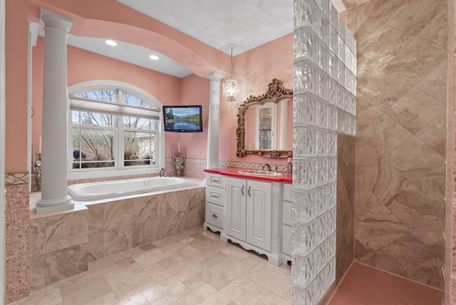 bathroom with a bath, decorative columns, vanity, and recessed lighting
