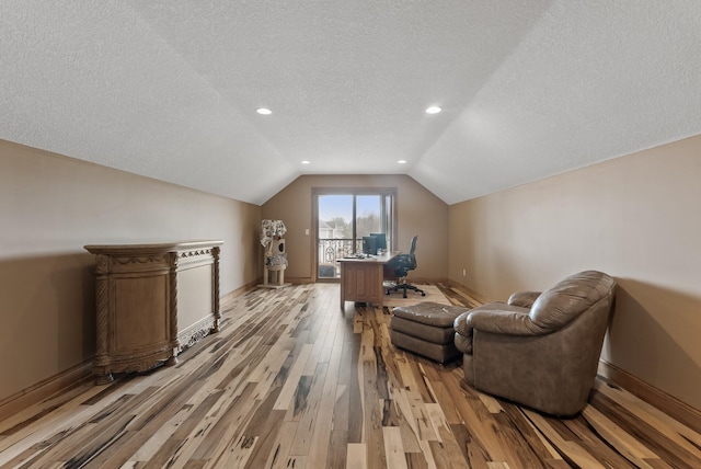 interior space with baseboards, a textured ceiling, recessed lighting, light wood finished floors, and vaulted ceiling