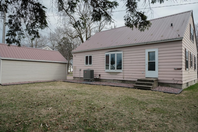 rear view of house with a yard, metal roof, and central AC unit
