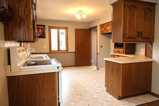kitchen featuring white range with electric cooktop, light floors, light countertops, a sink, and baseboards