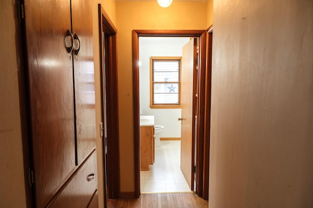 hallway with light wood finished floors and baseboards