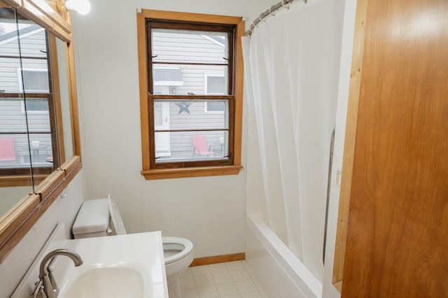 full bath featuring toilet, a healthy amount of sunlight, a sink, and tile patterned flooring