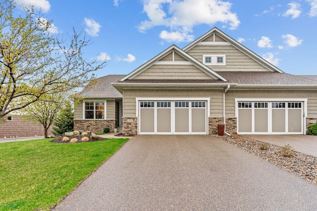 craftsman inspired home featuring a garage, a front lawn, stone siding, roof with shingles, and driveway