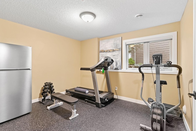 workout room featuring baseboards and a textured ceiling