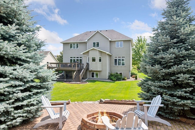 back of property featuring a patio, a wooden deck, stairway, a lawn, and a fire pit