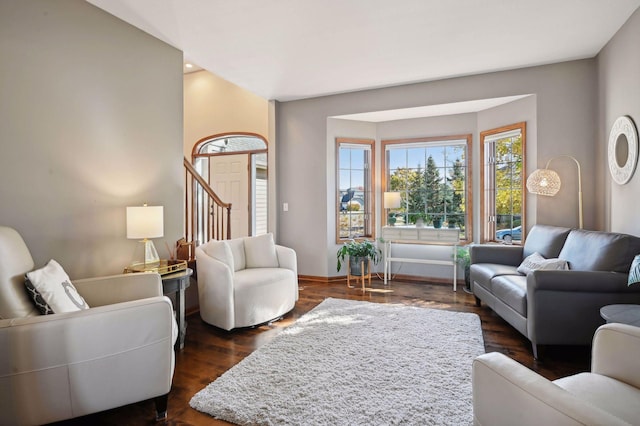 living area with dark wood-type flooring and baseboards