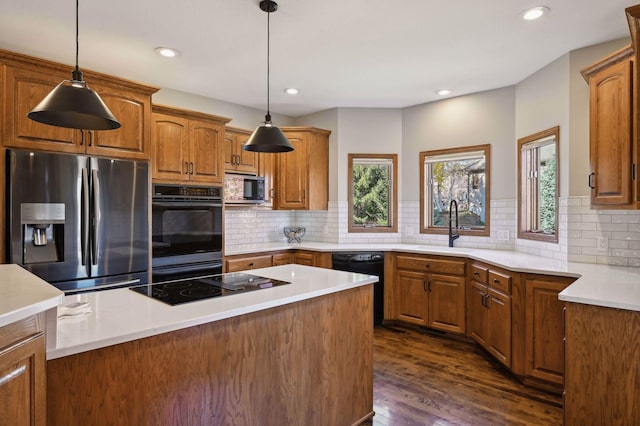 kitchen featuring black appliances, dark wood-style flooring, brown cabinetry, and a sink