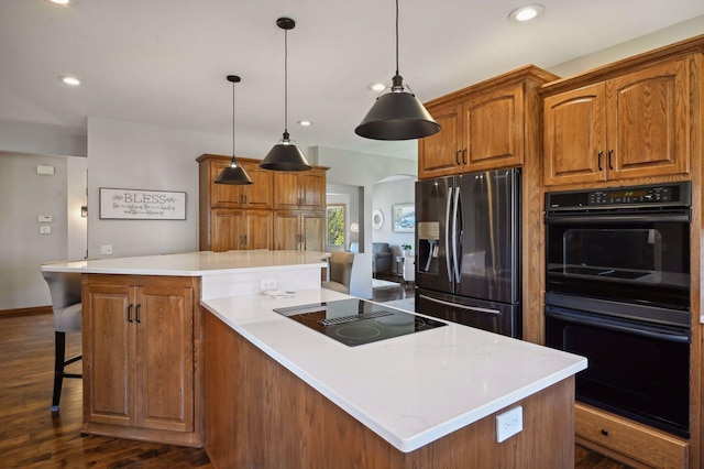 kitchen with light countertops, a center island, black appliances, recessed lighting, and dark wood finished floors