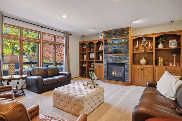 living area with a stone fireplace and light carpet