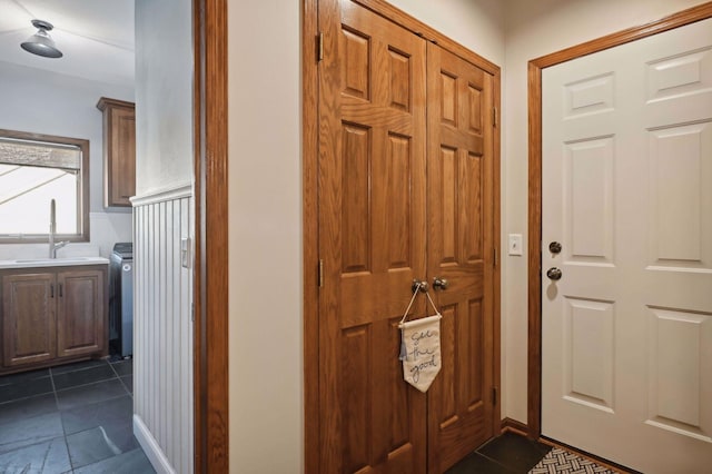 entryway with dark tile patterned floors