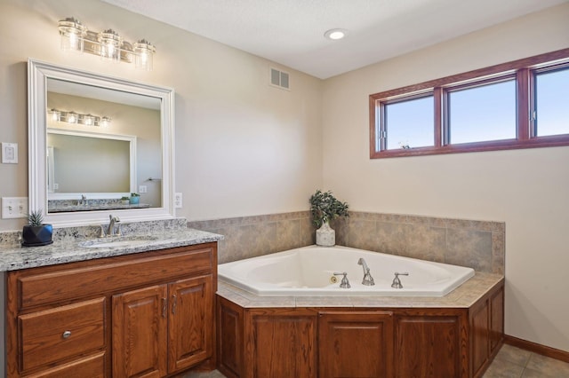 bathroom with a jetted tub, visible vents, tile patterned flooring, and vanity