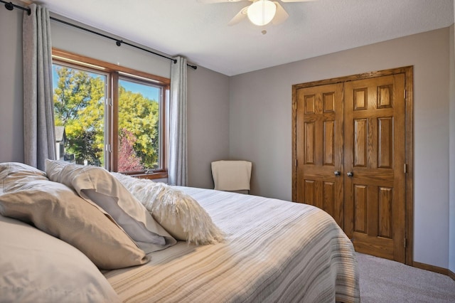 carpeted bedroom featuring a closet and a ceiling fan
