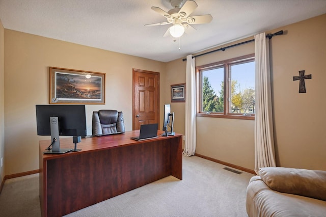 office space with visible vents, ceiling fan, light colored carpet, and baseboards