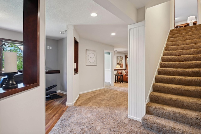 stairway with baseboards, recessed lighting, and carpet flooring