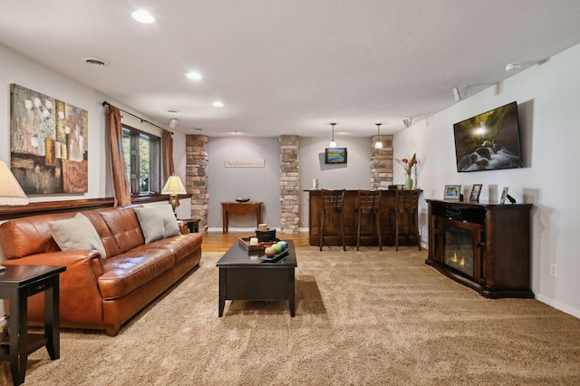 living area featuring bar area, recessed lighting, light carpet, and baseboards