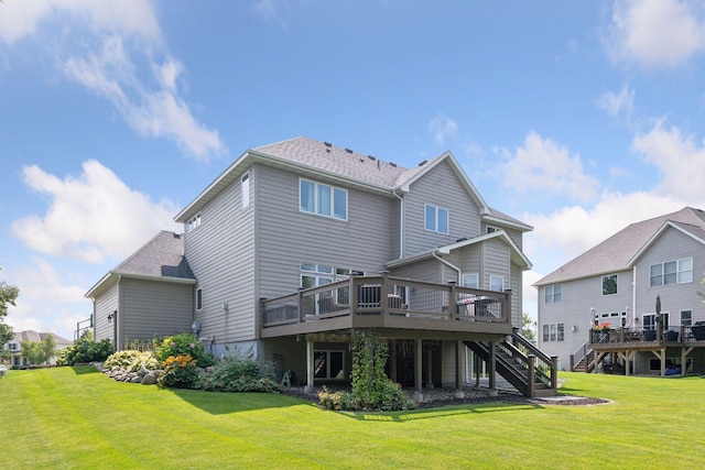 back of property featuring stairway, a wooden deck, a shingled roof, and a lawn