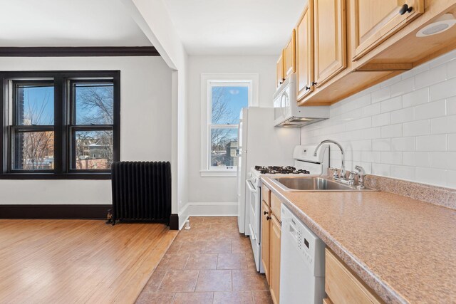 2218 Nicollet Ave Unit 22, Minneapolis, MN 55404 - kitchen featuring radiator, white appliances, light brown cabinetry, decorative backsplash, and a sink