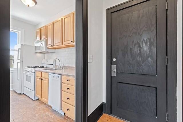 2218 Nicollet Ave Unit 22, Minneapolis, MN 55404 - kitchen featuring light countertops, backsplash, a sink, light brown cabinetry, and white appliances