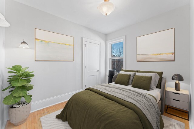 2218 Nicollet Ave Unit 22, Minneapolis, MN 55404 - bedroom with radiator heating unit, baseboards, and wood finished floors