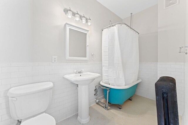 2218 Nicollet Ave Unit 22, Minneapolis, MN 55404 - bathroom featuring visible vents, toilet, tile walls, and wainscoting