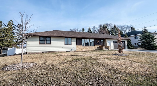 ranch-style house with an attached garage, a front lawn, roof with shingles, and concrete driveway