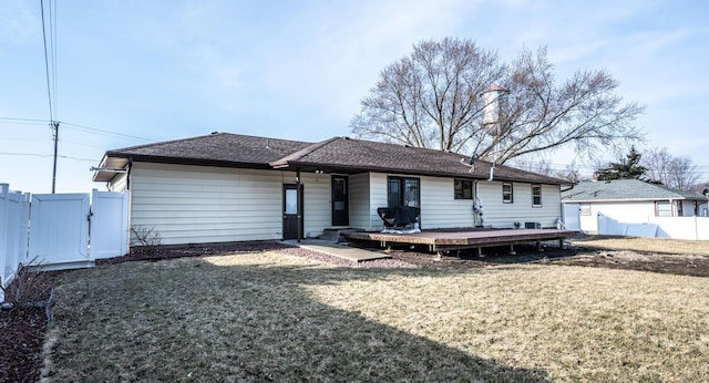 rear view of house featuring a gate, fence, a lawn, roof with shingles, and a deck