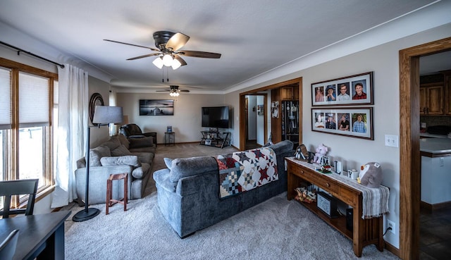 carpeted living room featuring ceiling fan and baseboards