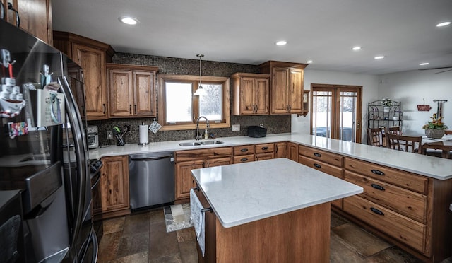 kitchen with black refrigerator with ice dispenser, stainless steel dishwasher, a sink, light countertops, and a peninsula