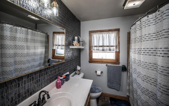 bathroom with backsplash, toilet, vanity, baseboards, and a shower with shower curtain