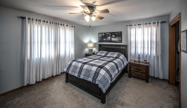 carpeted bedroom with ceiling fan, baseboards, and multiple windows