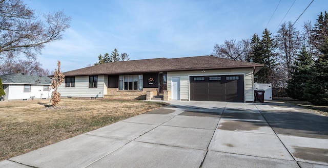 ranch-style house with an attached garage, a front lawn, and concrete driveway