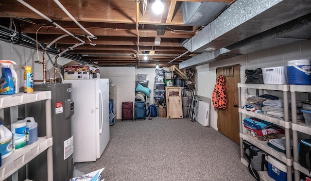 unfinished basement featuring carpet floors, white fridge, and electric water heater