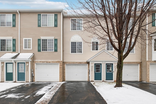 multi unit property featuring driveway and an attached garage
