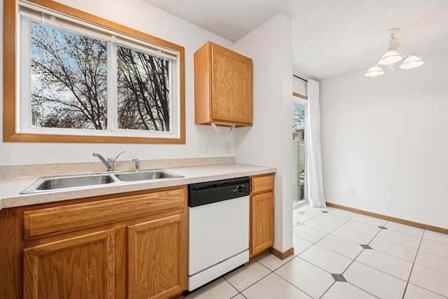 kitchen featuring a sink, light countertops, white dishwasher, and an inviting chandelier