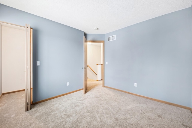 unfurnished bedroom with baseboards, visible vents, carpet flooring, and a textured ceiling