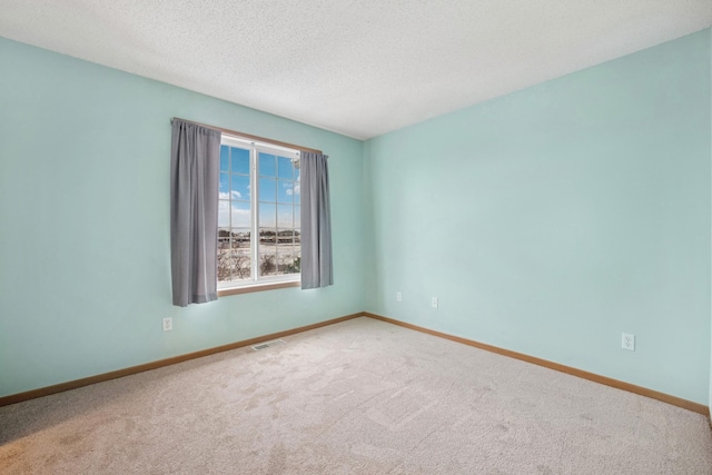 unfurnished room with baseboards, visible vents, and carpet floors