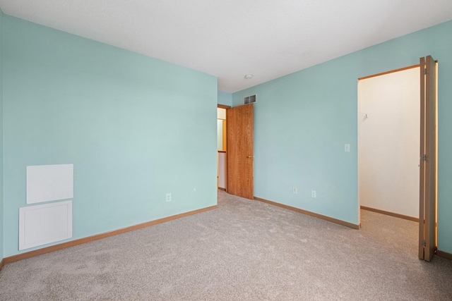unfurnished bedroom with baseboards, visible vents, and carpet