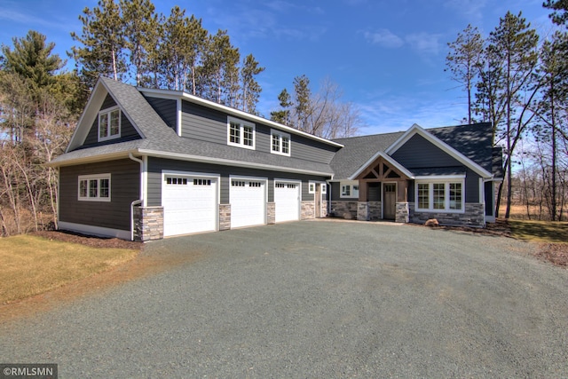 craftsman inspired home with a garage, roof with shingles, driveway, and stone siding