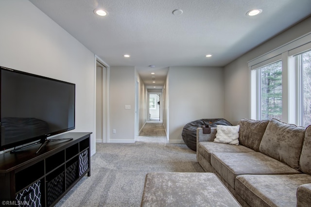 living room featuring light carpet, baseboards, and recessed lighting