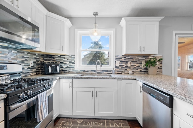 11345 Brenda Blvd, Becker, MN 55308 - kitchen with appliances with stainless steel finishes, a sink, white cabinets, decorative backsplash, and pendant lighting