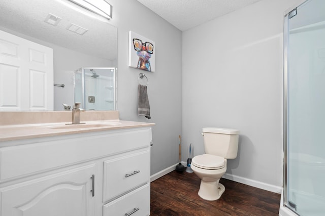 11345 Brenda Blvd, Becker, MN 55308 - bathroom featuring a textured ceiling, toilet, vanity, a shower stall, and wood finished floors